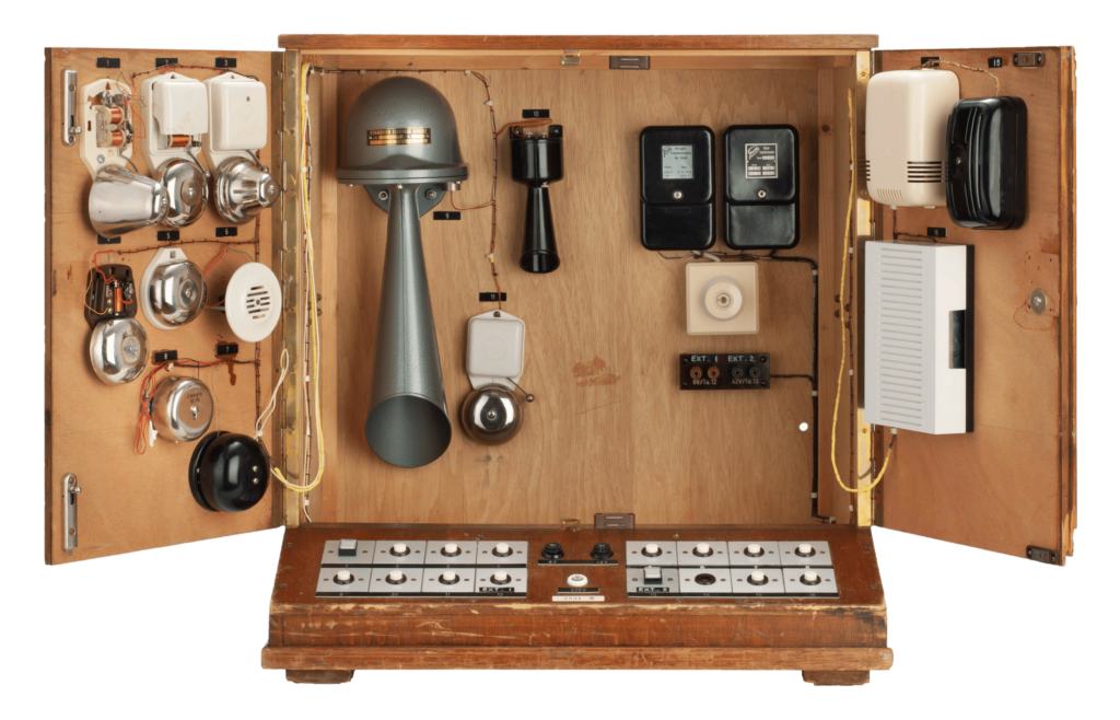 Klingelkasten aus Holz zur Hörspielvertonung. Im Kasten sind verschiedene Utensilien zur Klangerzeugung zu sehen, zum Beispiel eine Hupe.